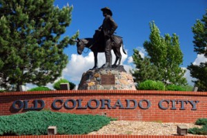 statue of a man on a horse and a sign in old colorado city
