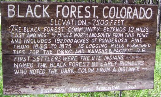 Wooden sign detailing the history of black forest colorado springs